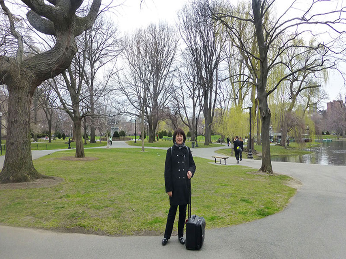 Christine Cottrell with suitcase in Boston park before attending the 2012 Specialty Coffee Association of America Event