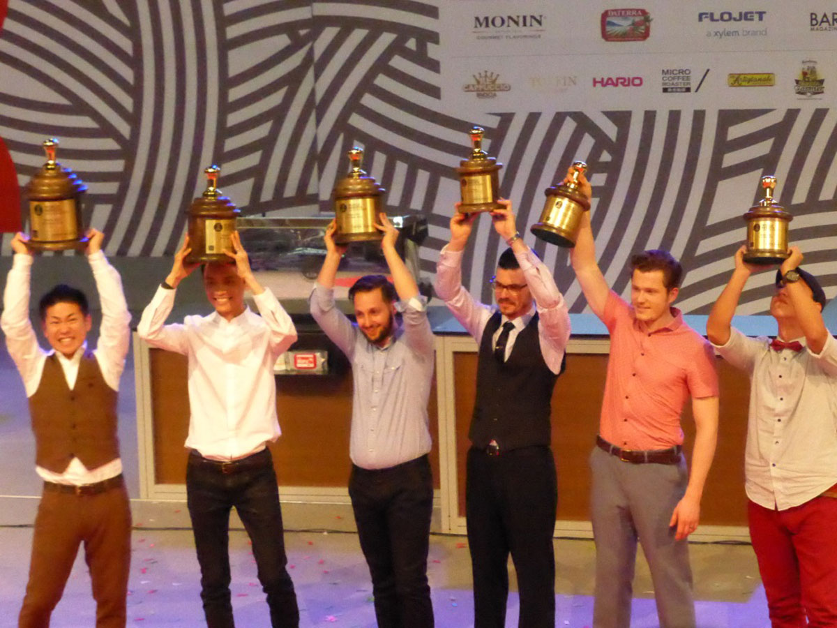 World Barista Championship finalists including the winner, Hidenori Izaki and Australian Craig Simon at 2014 World of Coffee in Rimini with Reg Barber trophies