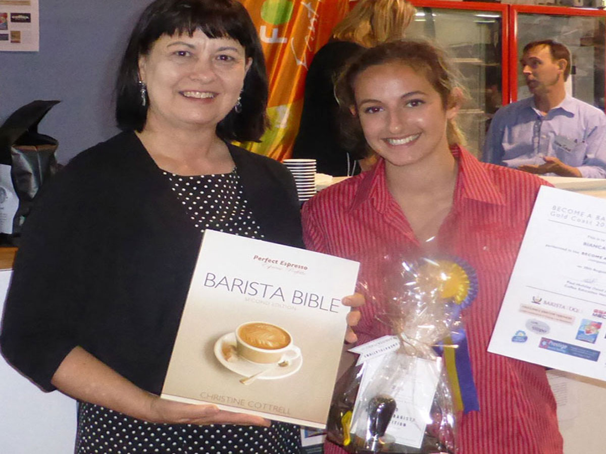 Christine Cottrell presenting a Barista Bible and prizes to the winner of the 2013 Become a Barista competition winner staged at the Gold Coast Show