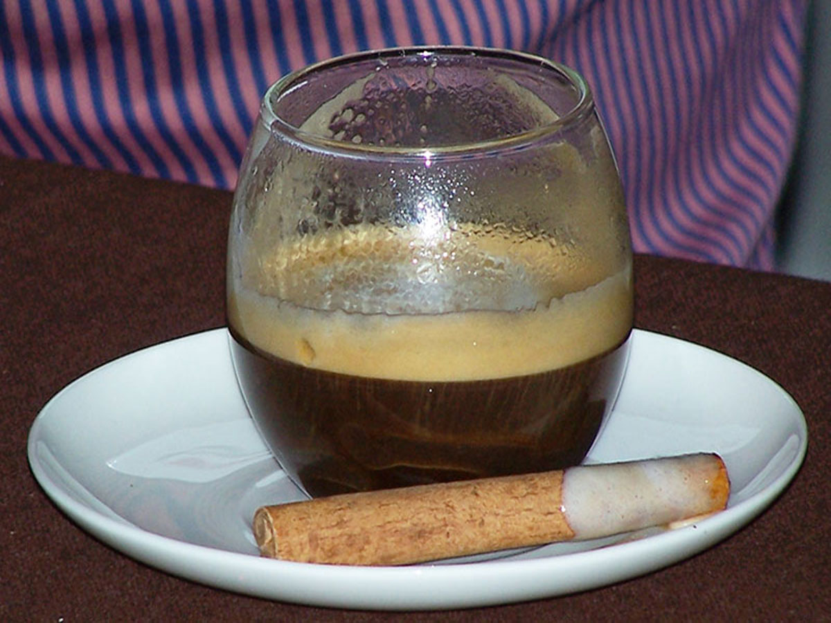 2011 Become A Barista competition signature beverage in a small rounded glass with cinnamon stick on the saucer
