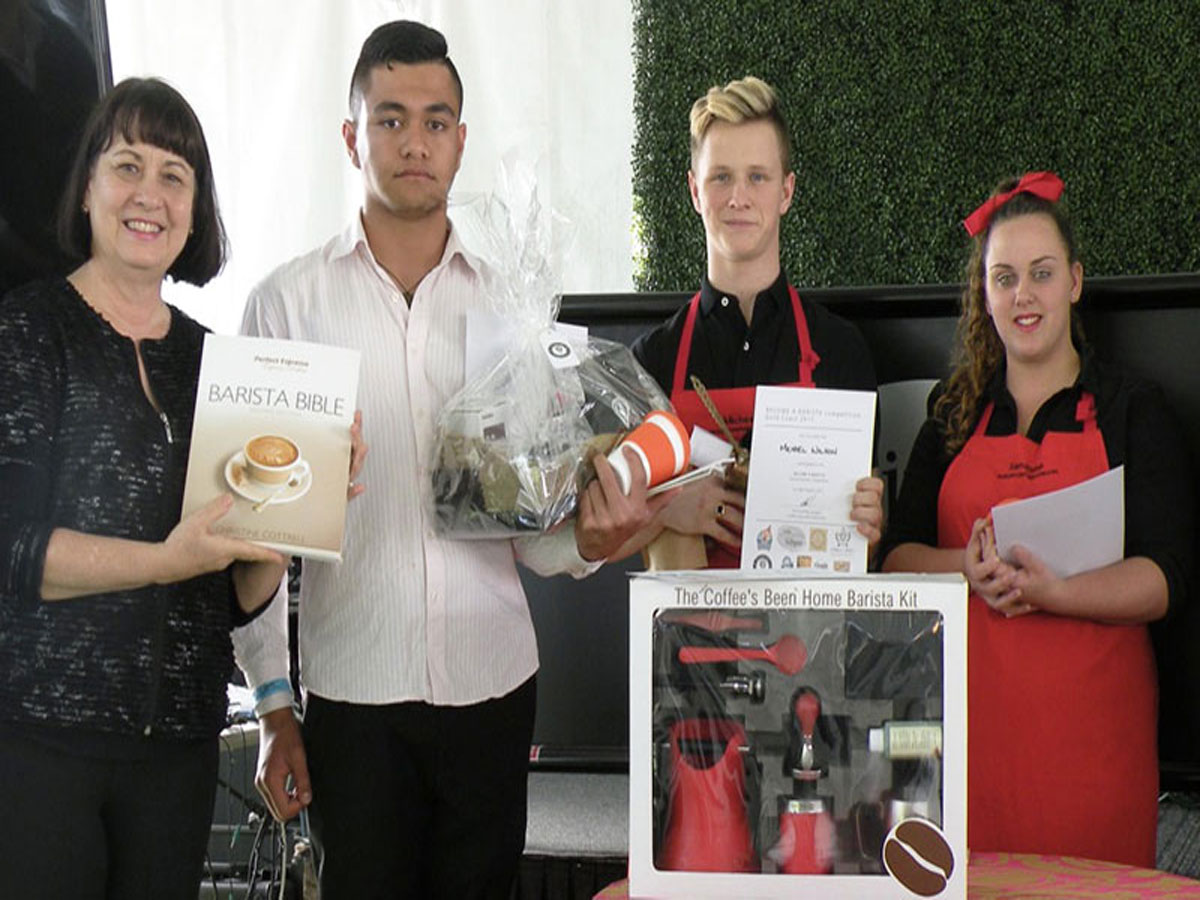 Christine Cottrell holding a Barista Bible with the three winners of the 2015 Become A Barista competition at the Gold Coast Show